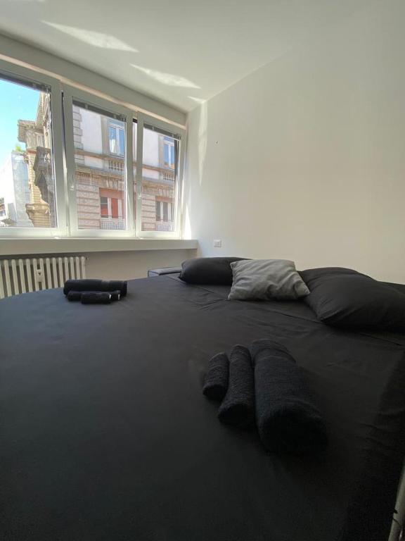 czarne łóżko z dwoma parami kapci w obiekcie [Udine Centro] Ade Apartment w mieście Udine