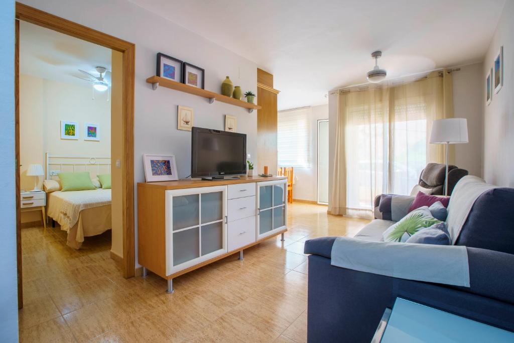 uma sala de estar com um sofá e uma televisão em Apartament a vila marinera em Les Cases d'Alcanar