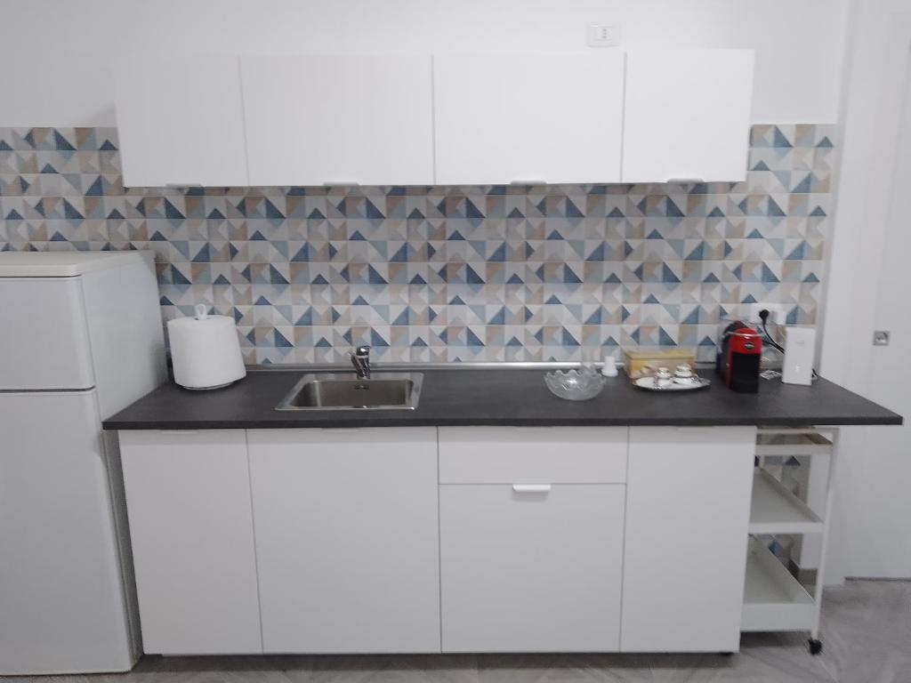 eine Küche mit weißen Schränken und einem Waschbecken in der Unterkunft U' Pastus in Bari