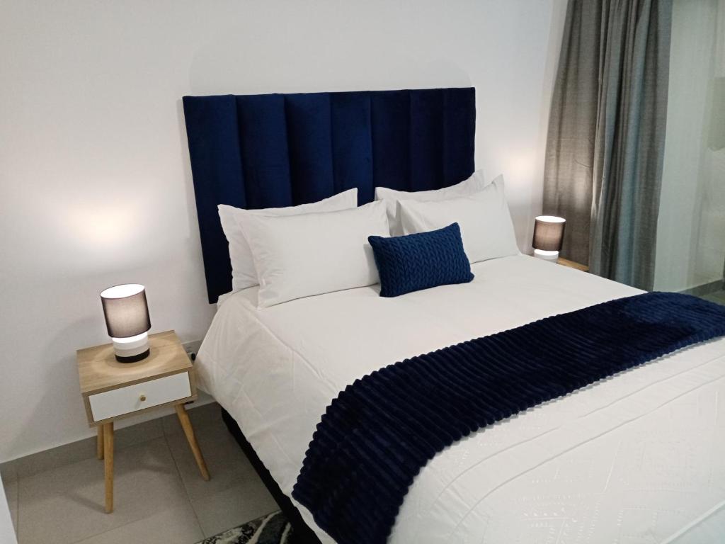 a bedroom with a large bed with a blue headboard at Villa 86, Ballito in Ballito