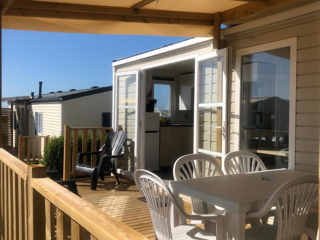 a patio with a table and chairs on a deck at La côte sauvage - MH climatisé 2018 - P30 - Le Portel in Le Portel