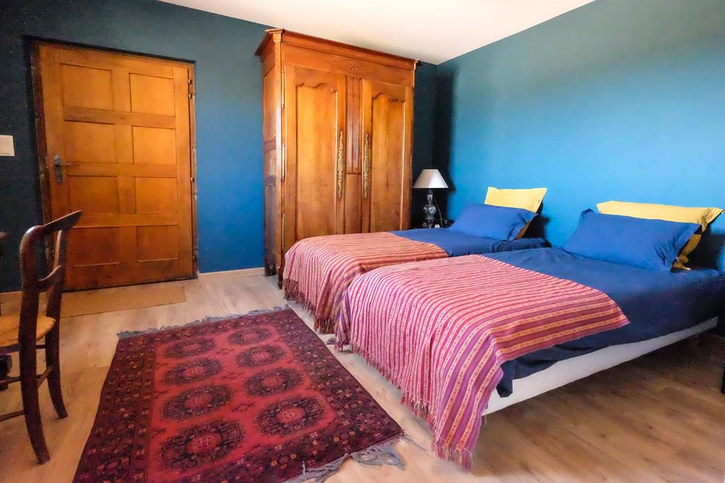 a bedroom with a bed with blue walls and a door at Mazille Les Trois Monts in Mazille