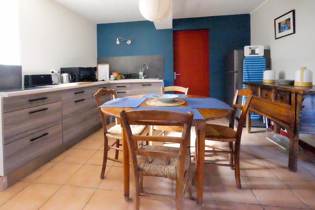 a kitchen with a table and chairs in a room at Mazille Les Trois Monts in Mazille