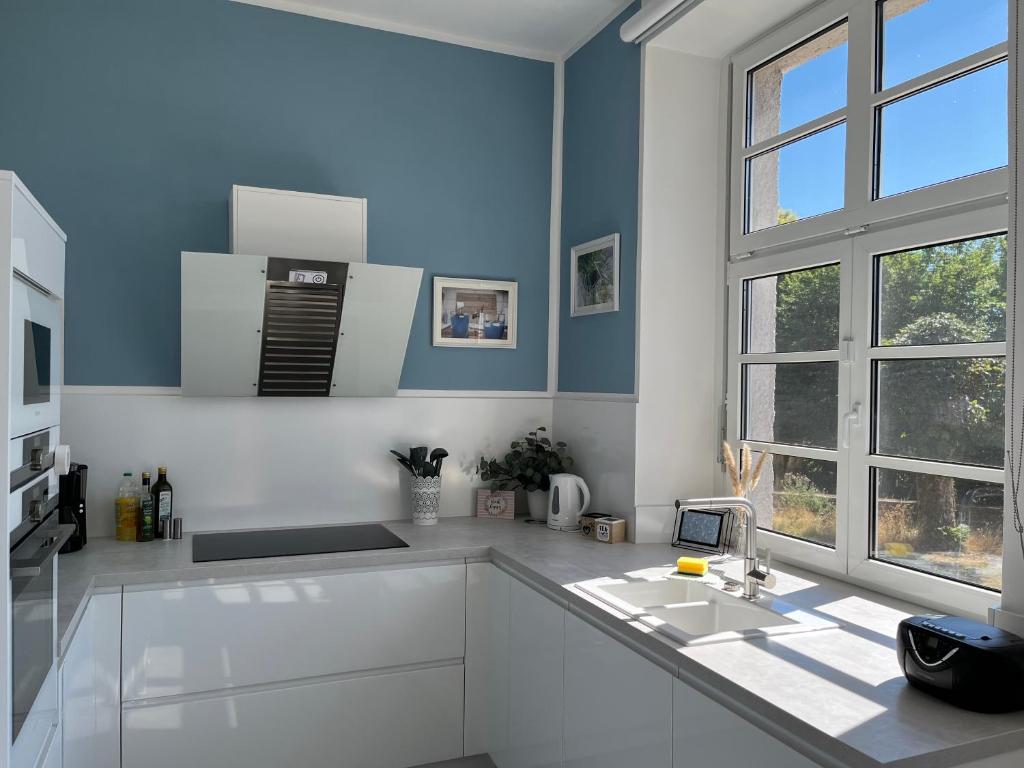 eine weiße Küche mit einem Waschbecken und einem Fenster in der Unterkunft Alte Schule Seinsfeld 