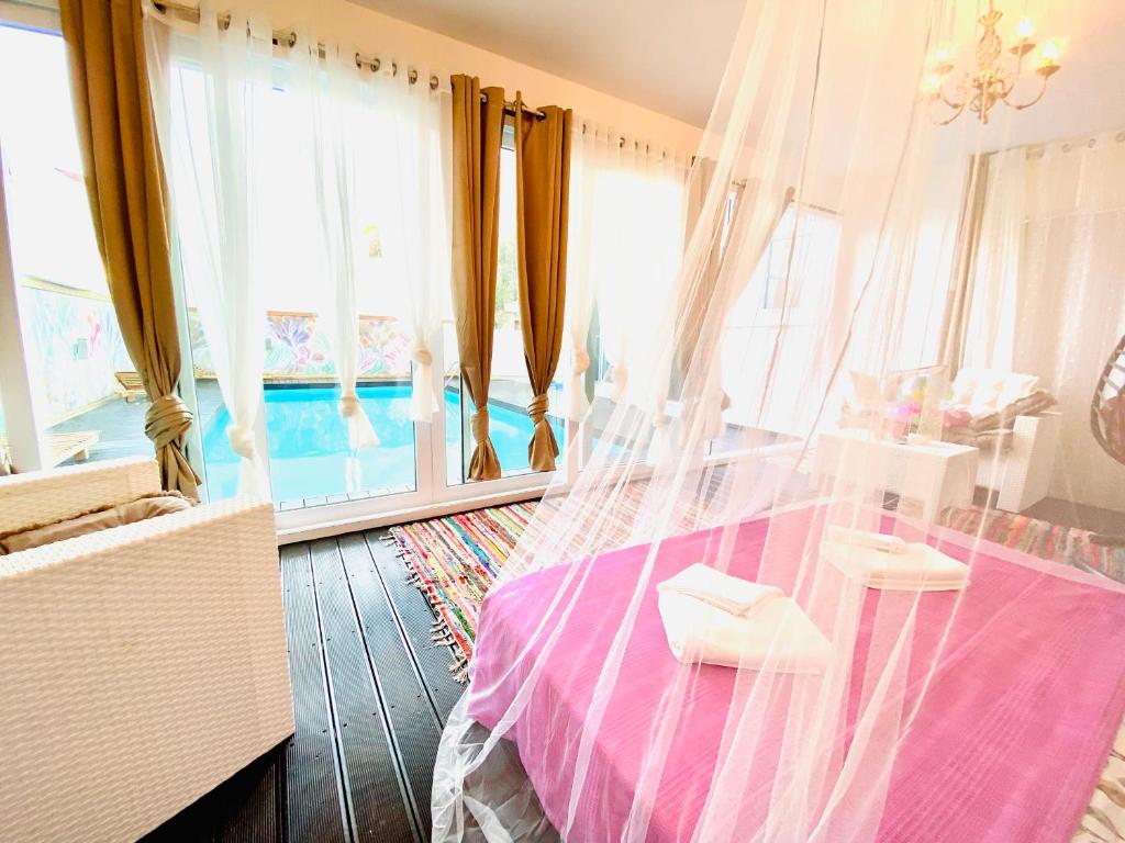 1 dormitorio con 1 cama con dosel y ventanas en Exclusive Villa Larnaca - 8 plus sleeps - 2 min from BEACH - Big Private Pool en Pyla