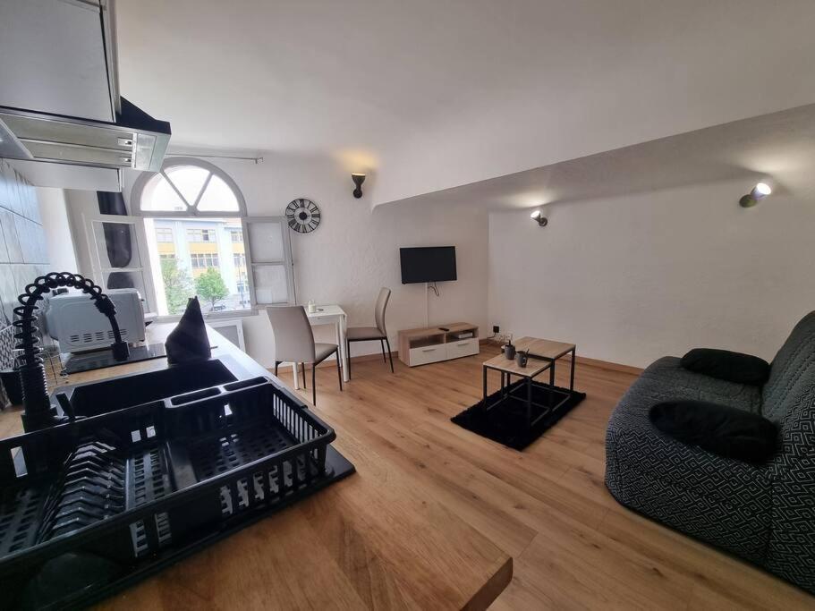 salon z kanapą, stołem i telewizorem w obiekcie Studio "Le Vauban" Perpignan Centre Ville w Perpignanie