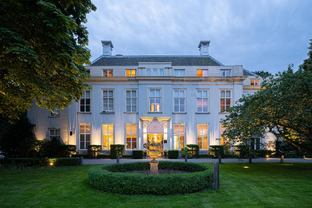 een groot wit huis met een tuin ervoor bij Central Park Voorburg - Relais & Chateaux in Voorburg