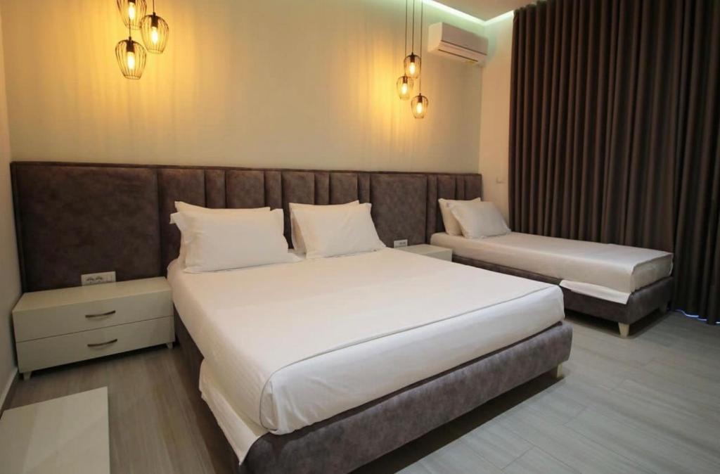 薩蘭達的住宿－Hotel LIDI，卧室配有白色大床和长凳