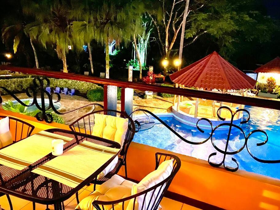 a patio with a table and chairs next to a pool at Lovely 2-BDroom Condo in Laguna Eco Village Resort in Quepos