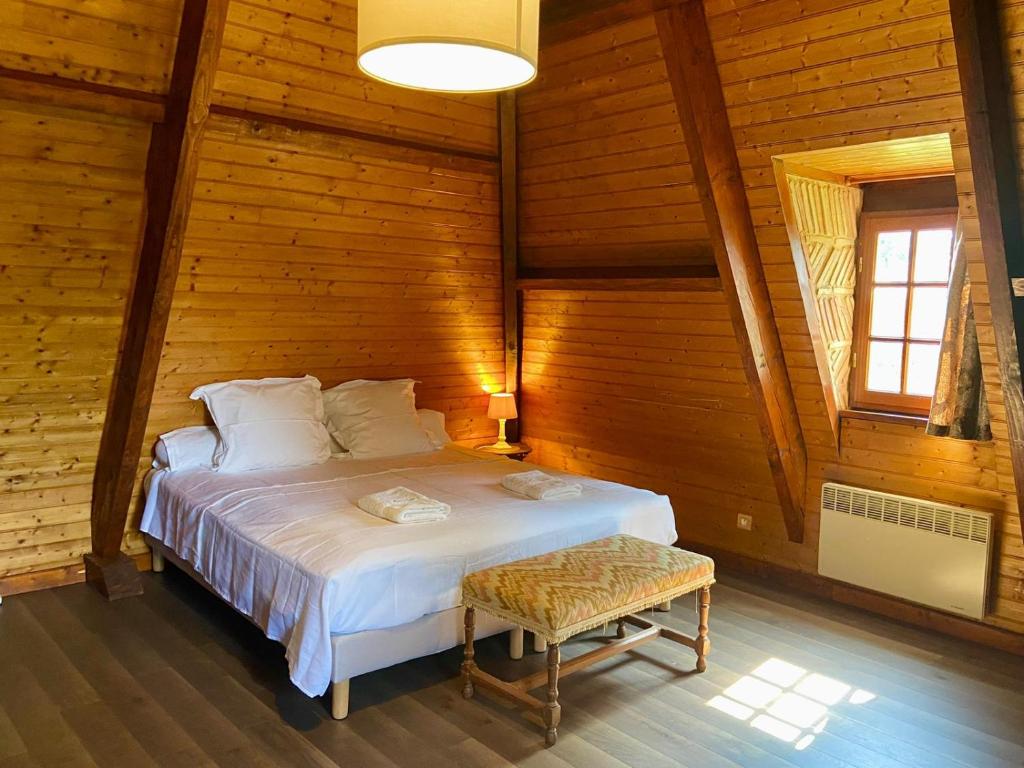a bedroom with a bed in a wooden room at Manoir du Suquet in Bardou