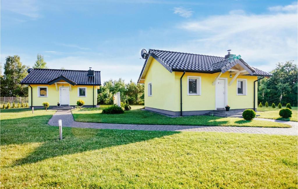 a yellow house with a yard at 2 Bedroom Cozy Home In Dabki in Dąbki