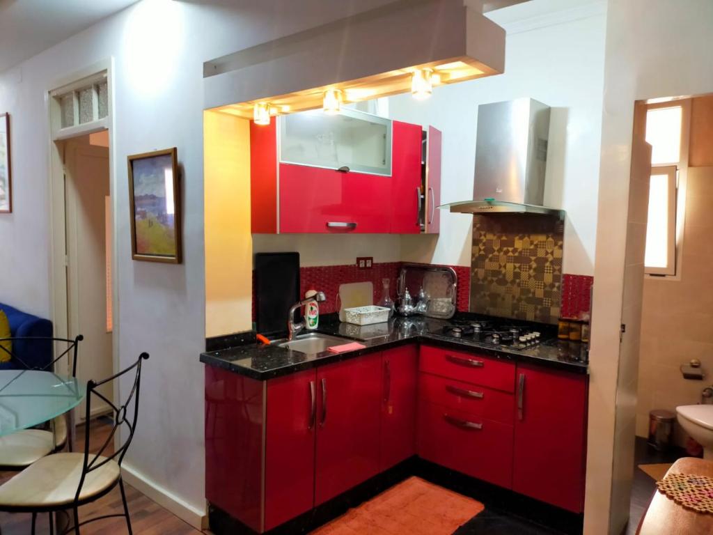 una cocina con armarios rojos y fregadero en Casa Tligui en Asilah