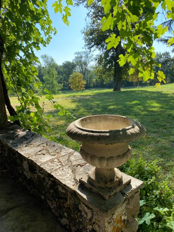 a stone bird bath sitting on a stone wall at Manoir du Suquet in Bardou