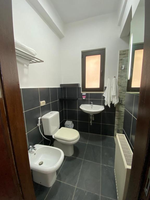 a bathroom with two toilets and a sink at Lemon Tree Residence in Amman
