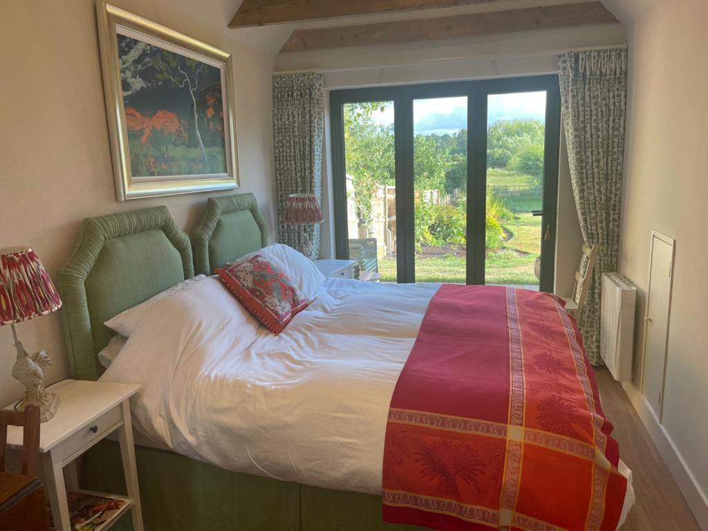 a bedroom with a bed and a large window at Garden Studio in Newbury