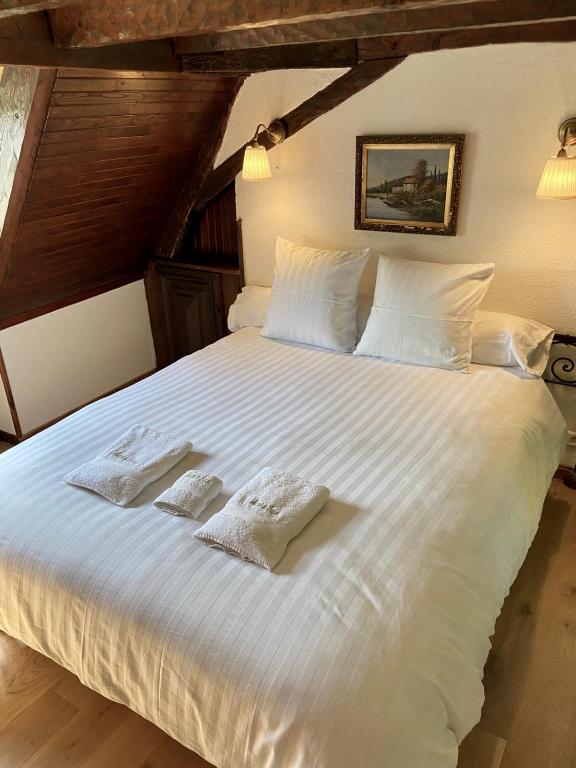 a large white bed with two towels on it at Manoir du Suquet in Bardou