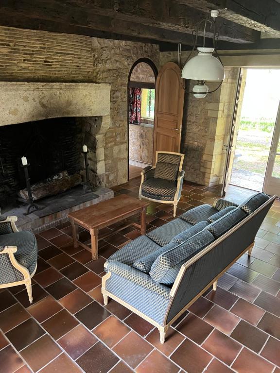 a living room with a couch and a fireplace at Manoir du Suquet in Bardou