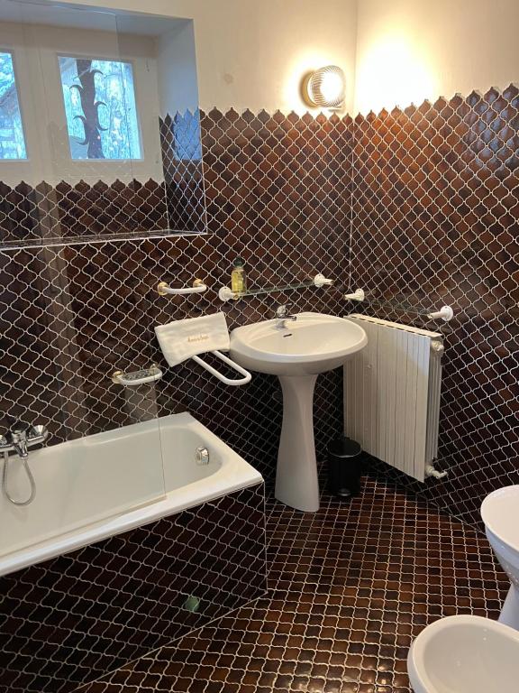 a bathroom with a sink and a toilet and a tub at Manoir du Suquet in Bardou