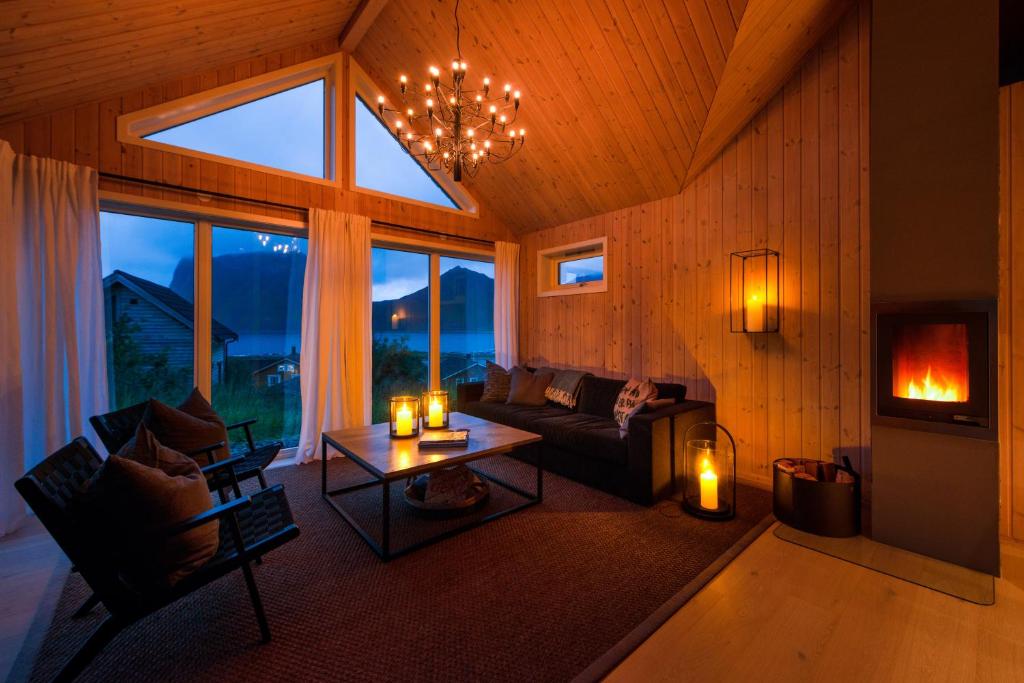 ein Wohnzimmer mit einem Sofa und einem Tisch mit Kerzen in der Unterkunft Haukland beach panorama in Offersøya