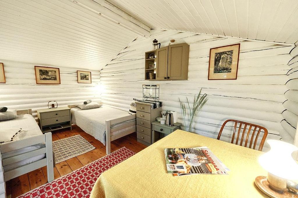 Habitación con 1 dormitorio y cocina con 2 mesas. en Muhu cabin Aasa en Igaküla