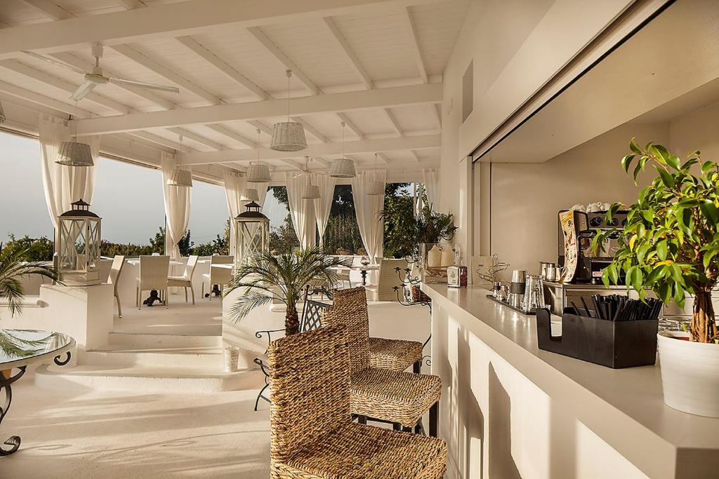 a lobby with a bar with chairs and plants at Tenuta Del Poggio Antico in Ischia