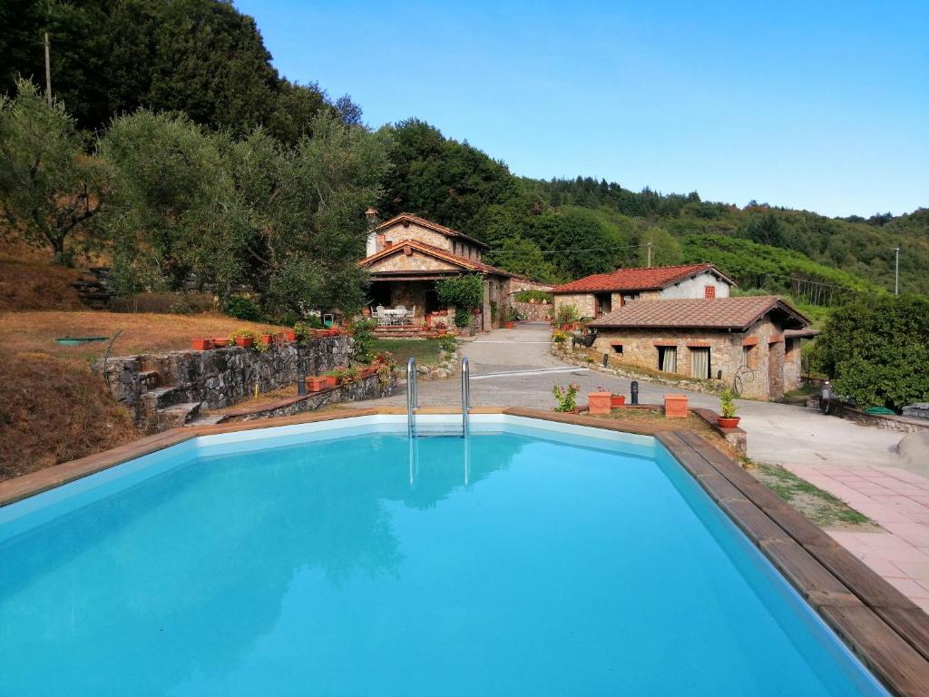 ein großer blauer Pool vor einem Haus in der Unterkunft Villa Armonia in Borgo a Mozzano
