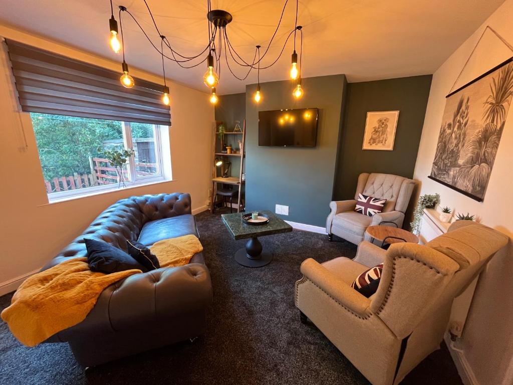 sala de estar con sofá de cuero y sillas en Modern three bedroom home, Hoyland, Barnsley en Hoyland Nether