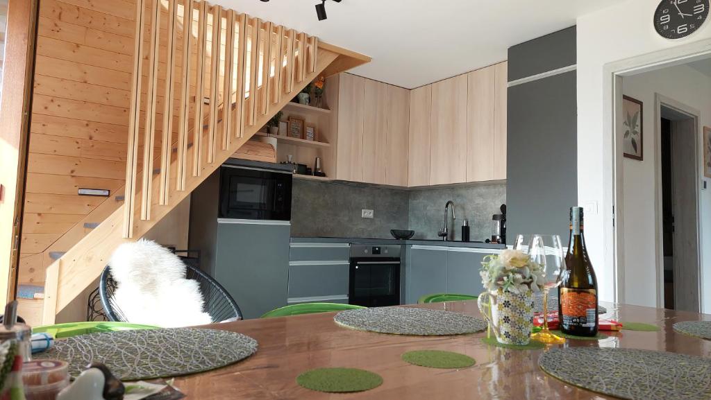 a kitchen with a table with chairs and a staircase at APARTMáN POD SMRČINOU in Vaclavov u Bruntalu