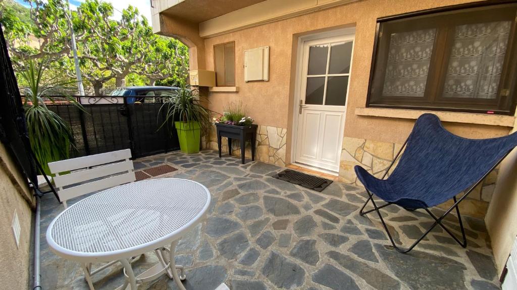 un patio con un tavolo e due sedie e una porta di Lavanda Calme et climatisé au cœur de Molitg les Bains a Moltig les Bains