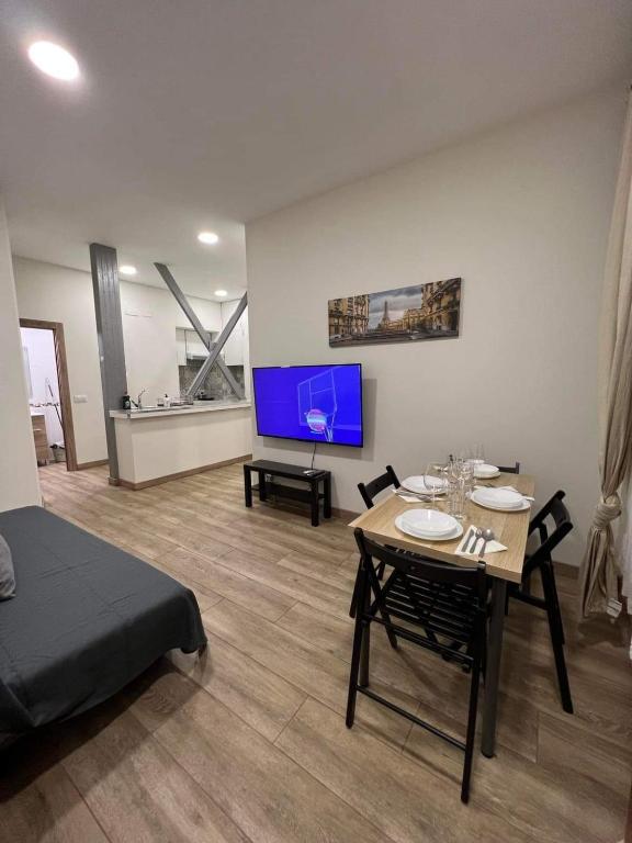 ein Wohnzimmer mit einem Tisch und einem TV in der Unterkunft PRADALONGO in Madrid