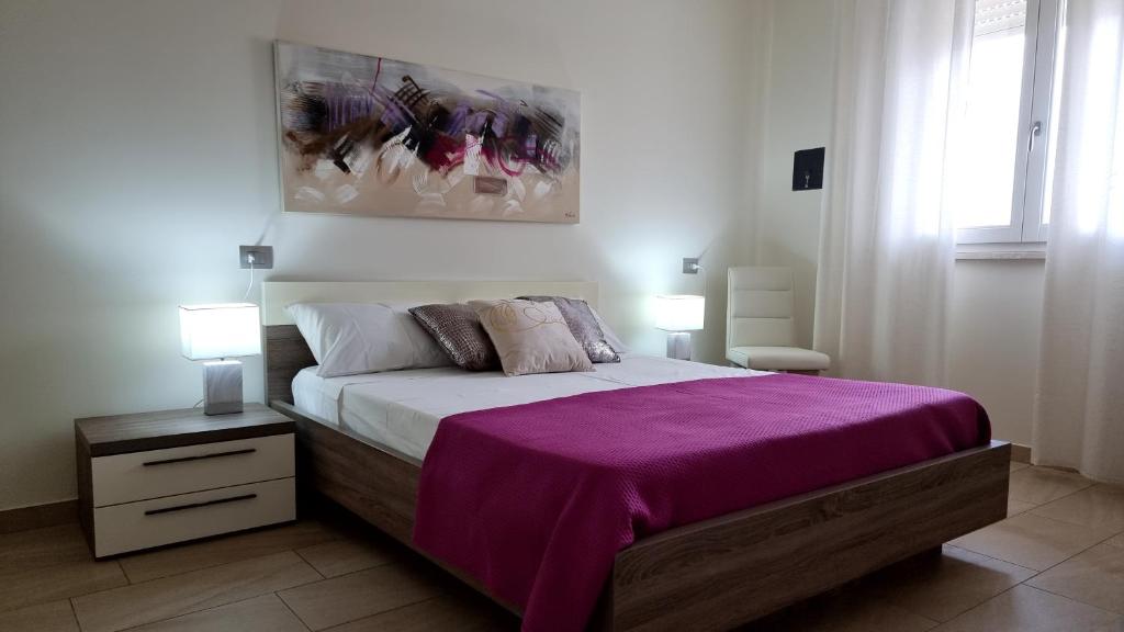 a bedroom with a large bed with a purple blanket at Benny's House in Alghero