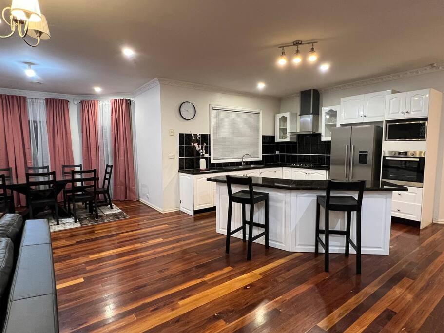 cocina y sala de estar con mesa y sillas en Affordable getaways, en Caroline Springs