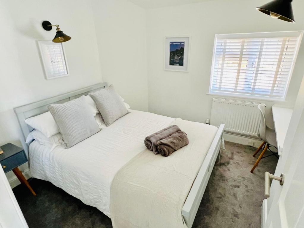 Kent的住宿－The Terrace - Tankerton，卧室配有白色的床和毛巾