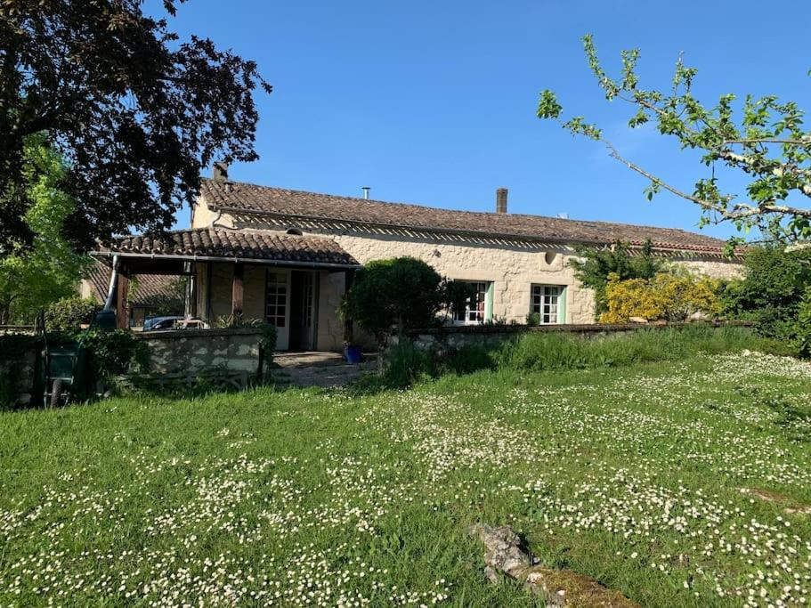 a house with a yard with white flowers in front of it at La Maison Pourpre in Vélines