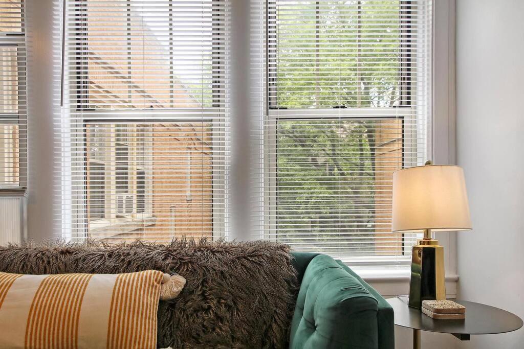 uma sala de estar com um sofá e duas janelas em Deluxe 1BR Apartment in Ravenswood - Campbell 3 em Chicago