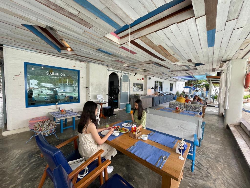 Dos mujeres sentadas en una mesa en un restaurante en The Oia Pai Resort, en Pai
