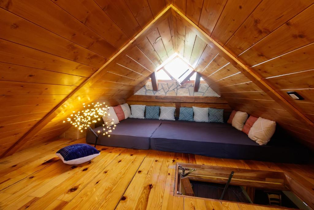 an attic room with a bed in a tree house at Mountain Villa Udovicic in Zlatibor