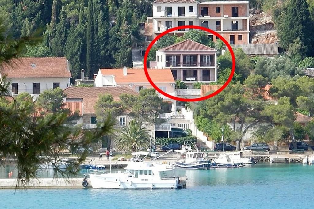 una casa en el agua con barcos delante en Apartments by the sea Loviste, Peljesac - 18656, en Lovište