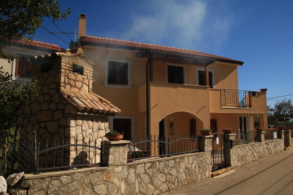 a large house with a stone wall at Apartments with a parking space Punta kriza, Cres - 18644 in Nerezine