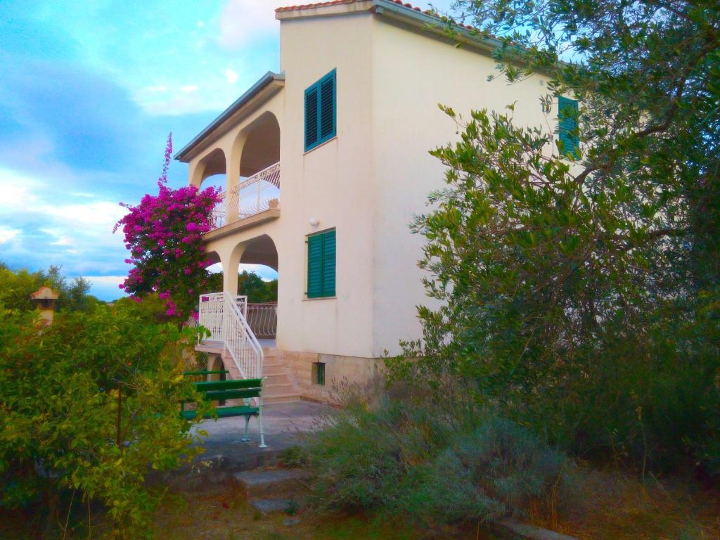 a white house with a bench in front of it at Apartments by the sea Necujam, Solta - 18664 in Grohote