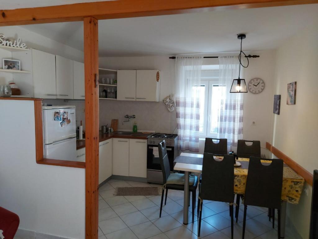 a kitchen and dining room with a table and chairs at Apartments by the sea Veli Iz, Iz - 18697 in Veli Iž