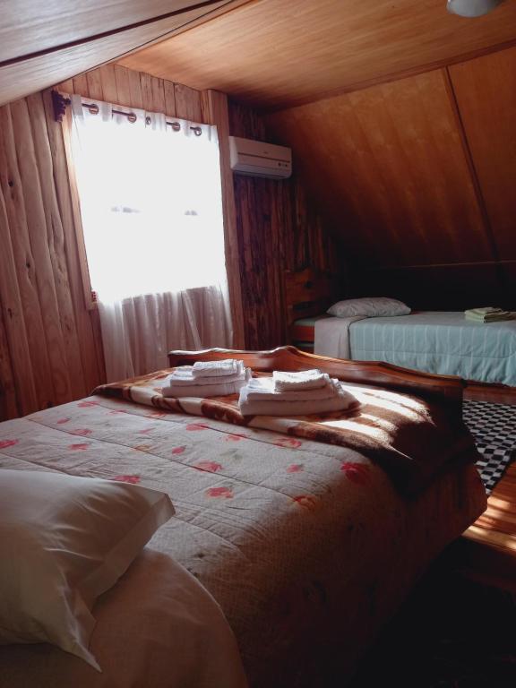 1 Schlafzimmer mit 2 Betten und einem Fenster in einem Zimmer in der Unterkunft Sítio Cabanas da Lu in Canela