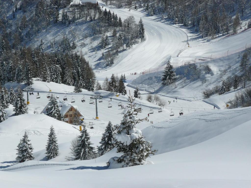 una pista de esquí cubierta de nieve con remonte en Baita Goles, en Sutrio