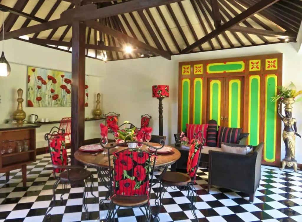 een eetkamer met een tafel en stoelen bij Red Palms in Blahbatu