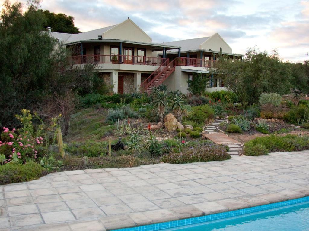 une maison avec un jardin et une piscine dans l'établissement Calitzdorp Country House, à Calitzdorp