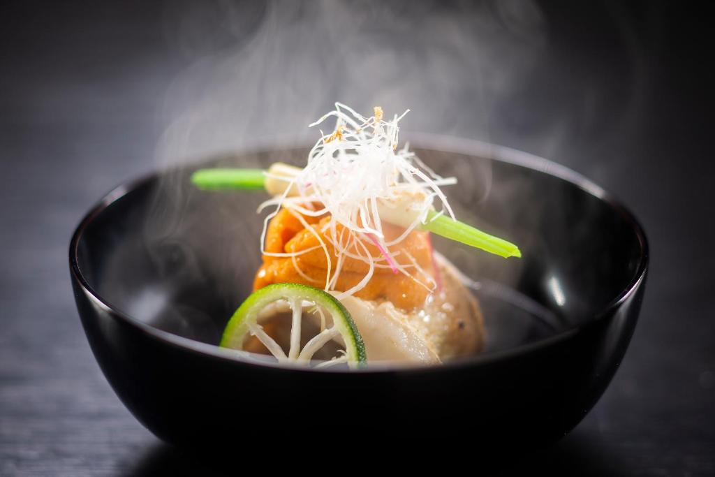 a black bowl of food with sushi and noodles at Kanazawa Hyakurakusou in Kanazawa