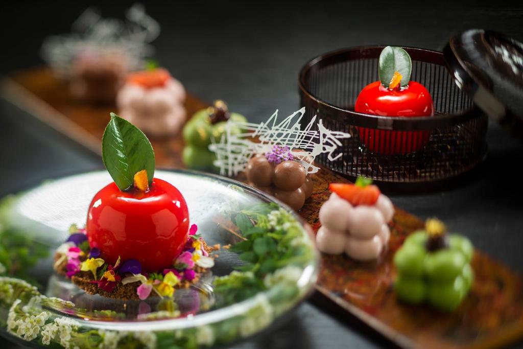 a table with a plate of food with red candles at Kanazawa Hyakurakusou in Kanazawa