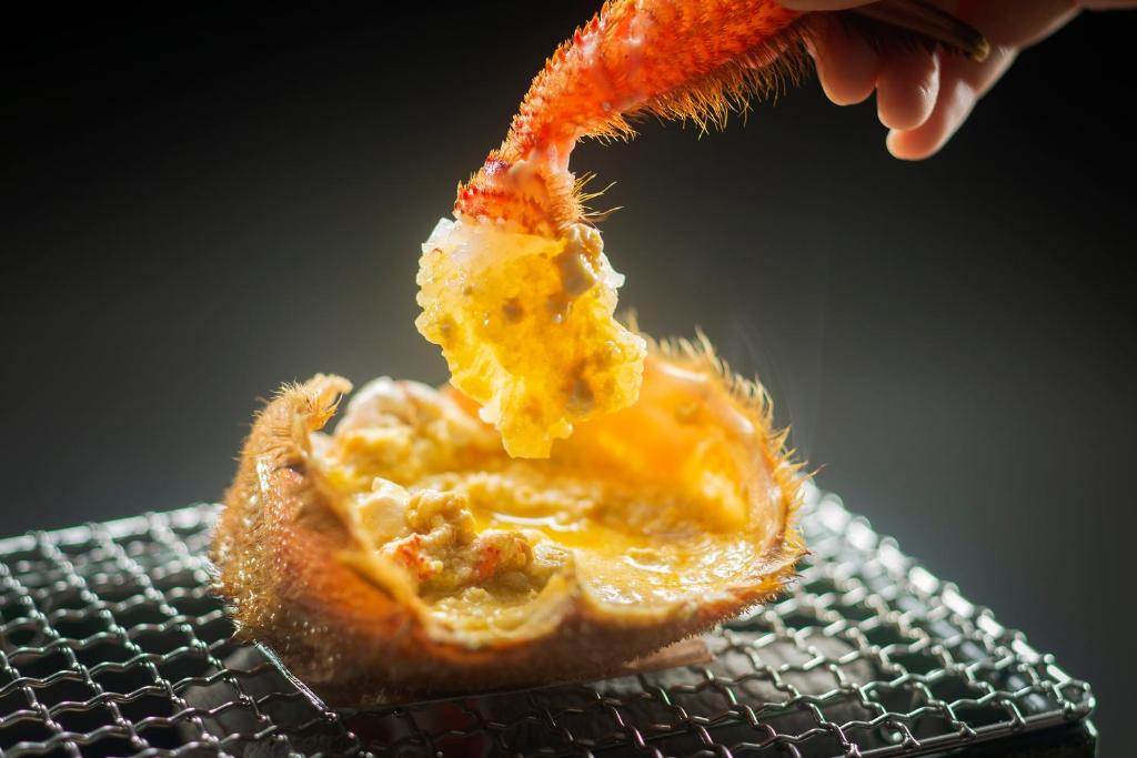a person is holding a piece of food at Kanazawa Hyakurakusou in Kanazawa