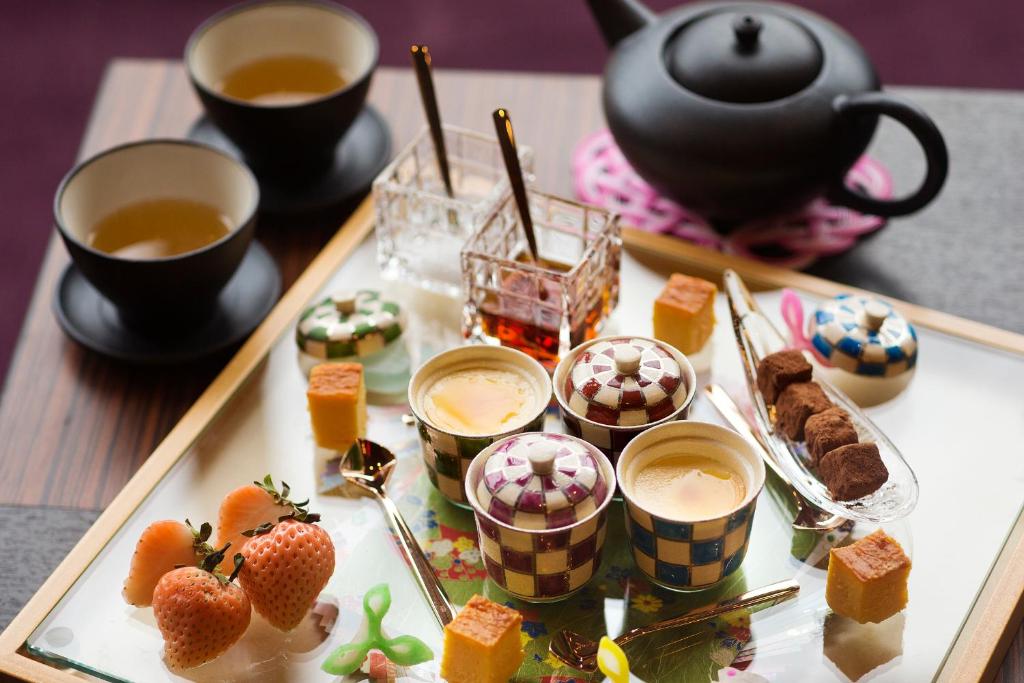 a tray of food with cups of tea and desserts at Kanazawa Hyakurakusou in Kanazawa