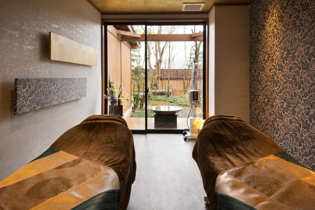 a living room with a couch and a large window at Kanazawa Hyakurakusou in Kanazawa